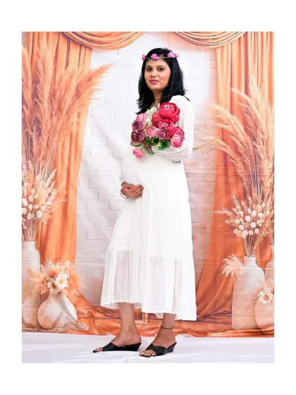 A lovely solo portrait in our Boho setup. The mom-to-be is wearing a simple white dress and a flower crown, holding a bouquet of peonies, which adds a touch of romantic softness to the earthy theme.