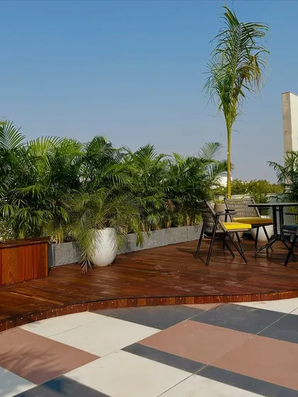 This image shows the transition from the tiled area to the raised wooden deck, which is bordered by a built-in wooden bench and planters.