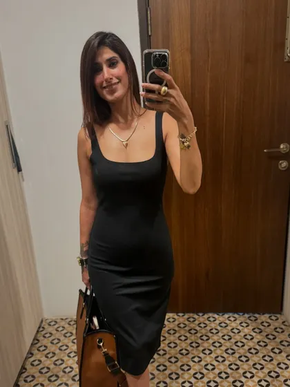 This is my go-to little black dress. The simple, body-hugging silhouette is incredibly versatile. Here, I've paired it with a classic tote bag for a look that's perfect for a networking event or a dinner out.