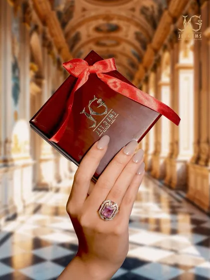 An unforgettable presence, this is what luxury feels like. This magnificent pink gemstone ring, held against our signature gift box, is a true treasure.