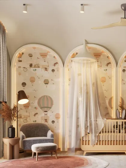 The nursery includes a cozy armchair and ottoman, perfect for late-night feedings or reading bedtime stories. A delicate canopy drapes over the crib, adding to the dreamy feel.