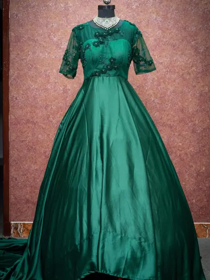 An emerald green gown with delicate floral embroidery on the sheer sleeves, perfect for an elegant evening affair.