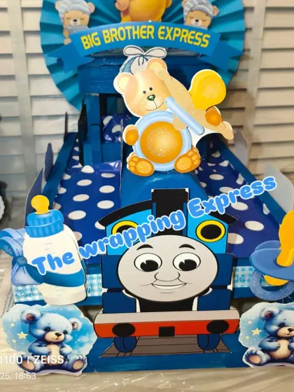 A close-up of the Thomas the Tank Engine design on the 'Big Brother Express', decorated with cute baby-themed cutouts.