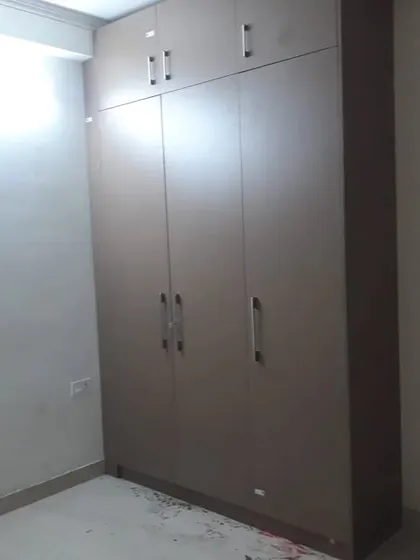 A simple yet spacious floor-to-ceiling wardrobe in a matte laminate finish, offering ample storage for a compact bedroom.