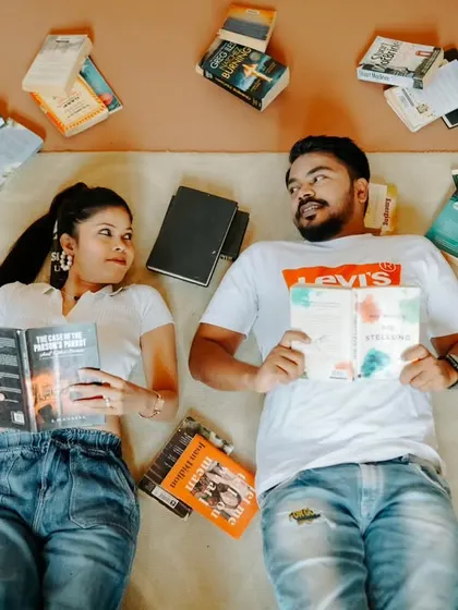An artistic flat-lay portrait of the couple surrounded by their favorite books. This creative shot is a fun and unique way to celebrate a shared interest.