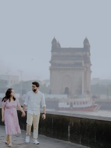 A classic romantic walk with the Gateway of India in the background, a perfect pre-wedding photo for a Mumbai-based couple.