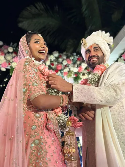The pure joy of a beach wedding. This happy couple, framed by a beautiful floral arch, perfectly captures the relaxed and celebratory spirit of a Goa wedding.