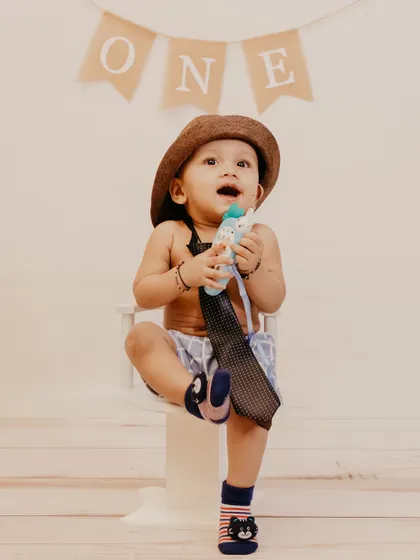 An adorable shot of a baby boy looking up with excitement during his first birthday photoshoot.