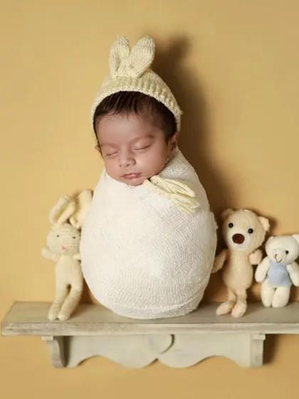 A slightly different angle of the potato sack pose, showing the baby's cute profile and bunny hat.