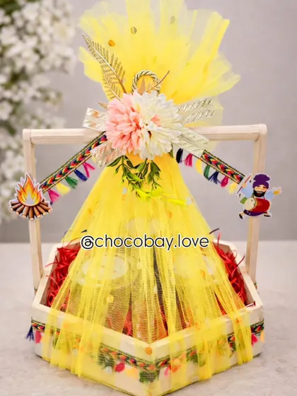I love bringing festive traditions to life. This bright yellow Lohri hamper is packed with seasonal favorites like gajak and rewari, and decorated with traditional Punjabi motifs to capture the spirit of the harvest festival.