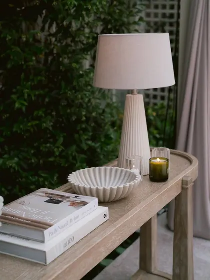 A beautifully styled console table from the "Ivory Dreamscape" event. The modern lamp, scented candle, and curated books create a vignette that makes the large venue feel as intimate as a home.