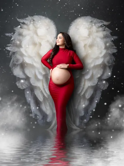 A heavenly portrait for a mother-to-be. We combined a gorgeous red gown with our angel wing prop and a dreamy, cloud-like setting to create this magical image.