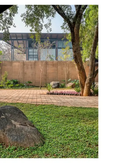 The earthen walls of the Lakeshore house feel just right. They connect the new structure to the older Mangalore tile building on the site, while rocks from the land are strewn throughout, retaining a sense of geological history.