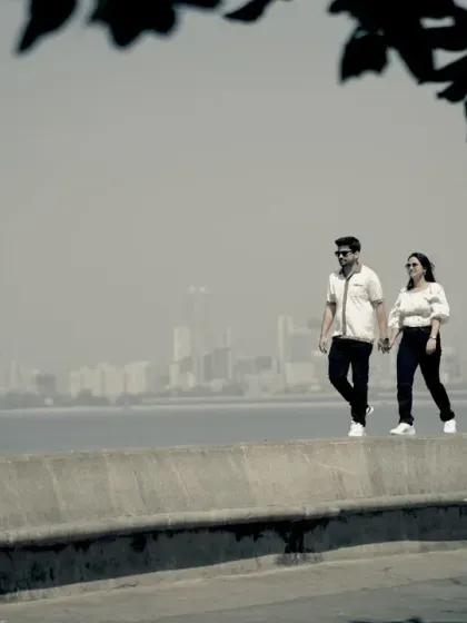 A casual stroll along Marine Drive for a pre-wedding shoot. The famous Queen's Necklace skyline provides a beautiful, hazy backdrop for relaxed and natural couple photos.