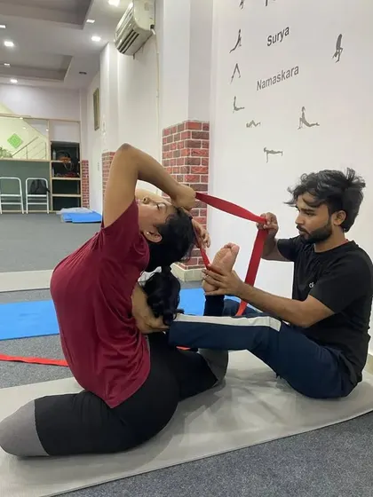 In our teacher training, I provide hands-on adjustments to help you find the correct alignment and deepen your postures safely. Here, I am assisting a student in Rajakapotasana (King Pigeon Pose) using a strap to gently open the shoulders and deepen the backbend.