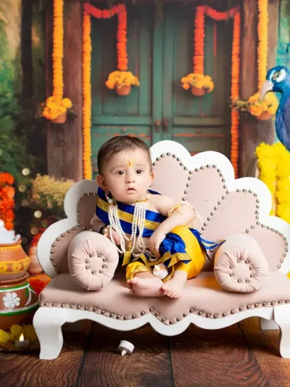 A regal pose from our little Krishna. The rich, forest-like backdrop and traditional Indian decor make these photos truly special.