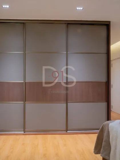 A large sliding wardrobe with frosted glass and wood-finish panels provides ample storage while maintaining a sleek look.