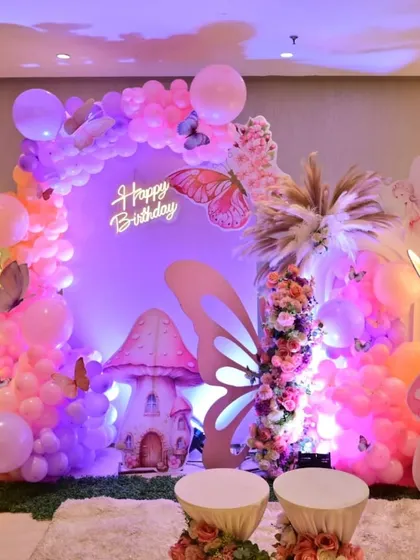 Creating this enchanted butterfly garden was a dream. The setup features a beautiful balloon arch in pastel shades, whimsical mushroom props, and glowing butterfly wings, all centered around a 'Happy Birthday' neon sign to make the celebration truly magical.