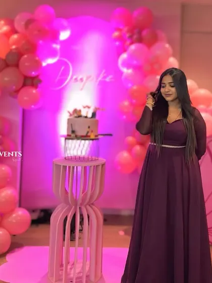 The birthday girl enjoying her pretty-in-pink butterfly-themed party. The shades of pink balloons and custom name sign create a perfect photo backdrop.