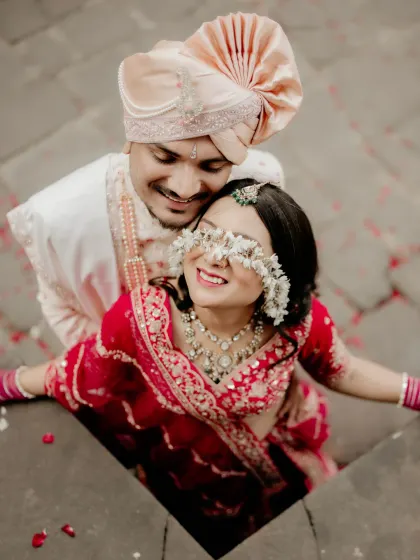 A creative and playful portrait of the couple, with flowers gently covering the bride's eyes. This adds an artistic and whimsical touch to their wedding album.
