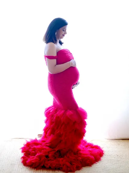 A high-key profile shot in a striking red mermaid-style gown. This technique uses a bright white background to create a clean, crisp, and modern portrait.