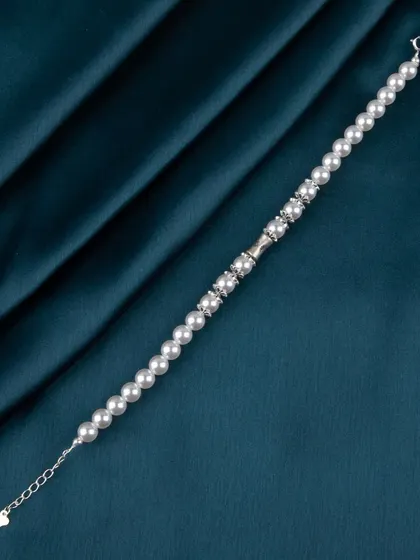 A full view of a pearl and silver bead bracelet.