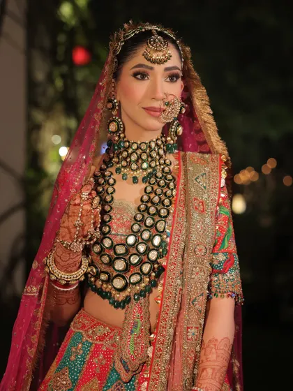 A side profile that highlights the beautiful details of her jewelry, the soft blush on her cheeks, and the elegant hair accessories.
