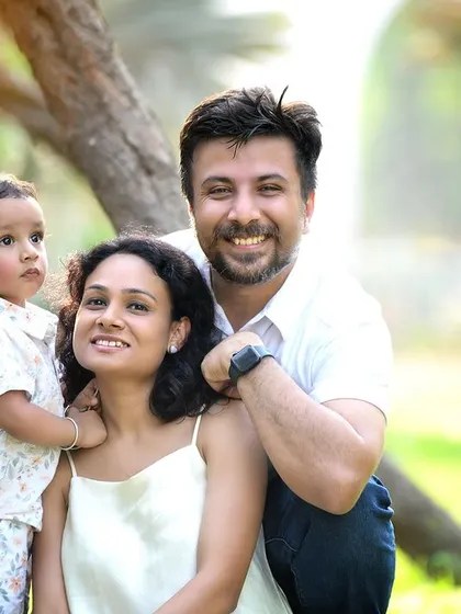 A loving family portrait taken outdoors. The warm sunlight and natural environment create a soft and beautiful glow.