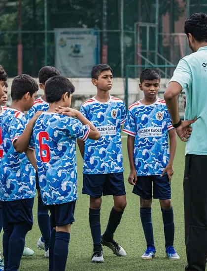 The U13 team gets a pep talk from the coaches. Strategy and communication are key elements we teach in our competitive youth football programs.