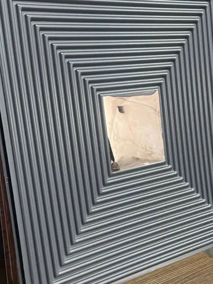 This grey PVC panel with a grooved design and silver mirror provides a sleek, modern, and industrial-chic aesthetic.