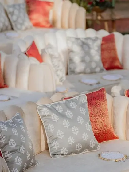 Custom cushions in shades of red, grey, and cream for the amphitheater seating at the 'Regal Rustic Reverie' wedding. These details added comfort and a touch of regal elegance.