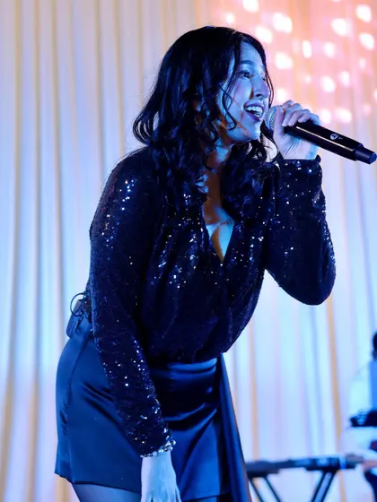 Singing under the blue lights at a private party. We work with event planners to ensure our stage setup and lighting complement the event's ambiance.