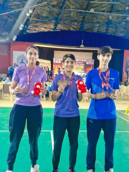 Niti, Alina, and Lakshay posing with their medals from the Delhi State tournament. Their success in mixed and individual events shows their versatility.