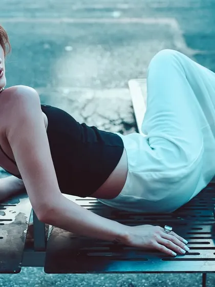 A cool, blue-toned shot on a city bench. The lighting is intentionally moody to create a cinematic, after-hours feel.