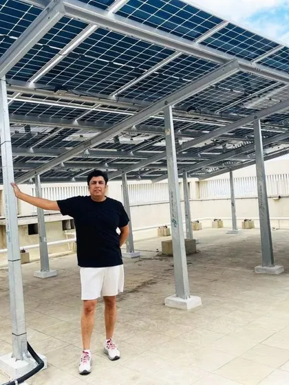 A resident of a Bangalore housing society proudly showcases his building's new rooftop solar system.