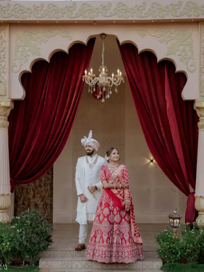 A wider shot of the couple standing in a grand archway, showcasing the beautiful venue.