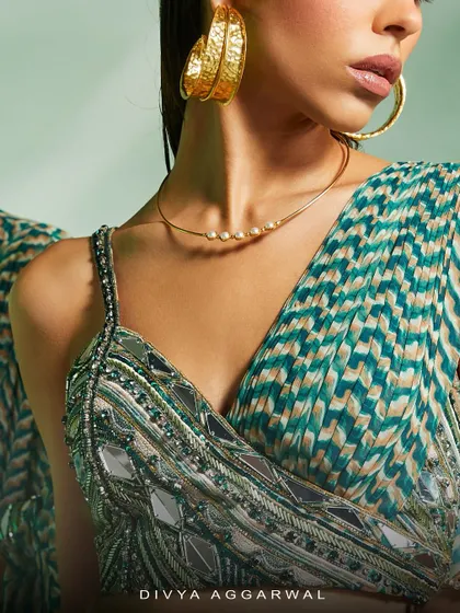 A close-up on the Verity set's asymmetrical blouse, where I used intricate mirror work and beading to create a modern yet traditional feel.