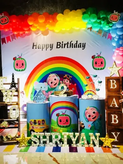 A complete Cocomelon setup for Shriyan's birthday, featuring the iconic yellow school bus, a rainbow backdrop, and character cutouts for a picture-perfect party.