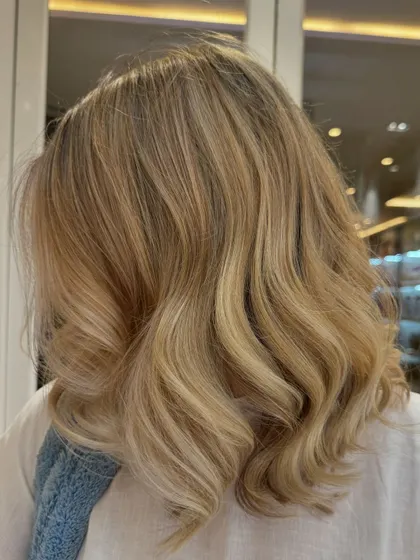 The soft waves in this pearl blond balayage highlight the beautiful colour work.