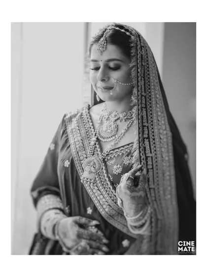 A timeless black and white portrait of the bride by a window, using natural light to create a soft and contemplative mood.