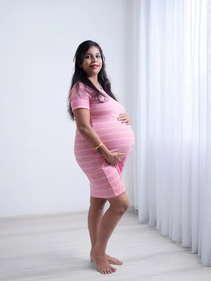 A simple, clean side-profile shot in our studio, beautifully highlighting the baby bump against a bright white background.