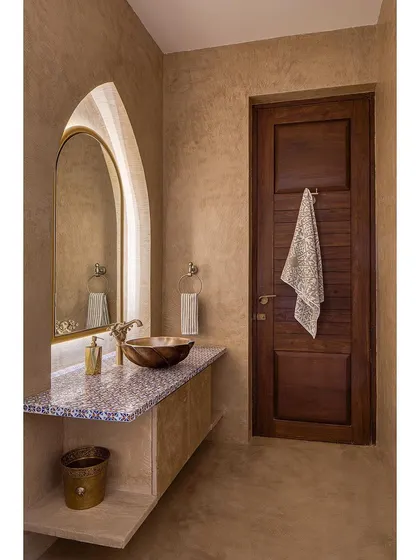 This bathroom at Casa Aum showcases our attention to detail. The design features hand-plastered walls, a custom vanity with mosaic tile, and an arched mirror, all contributing to its unique Moroccan-inspired aesthetic.