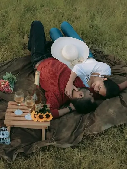 An aerial view of a romantic picnic setup in a grassy field. This type of pre-wedding shoot is perfect for capturing a relaxed and intimate story.