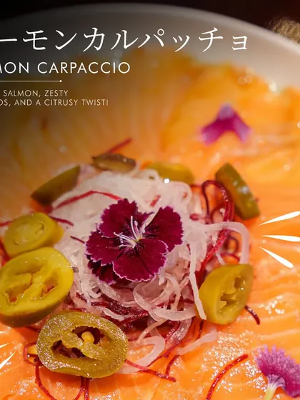 Our Salmon Carpaccio is a refreshing starter. Thinly sliced salmon is dressed with a zesty citrusy sauce and topped with jalapeños for a light, flavorful kick.