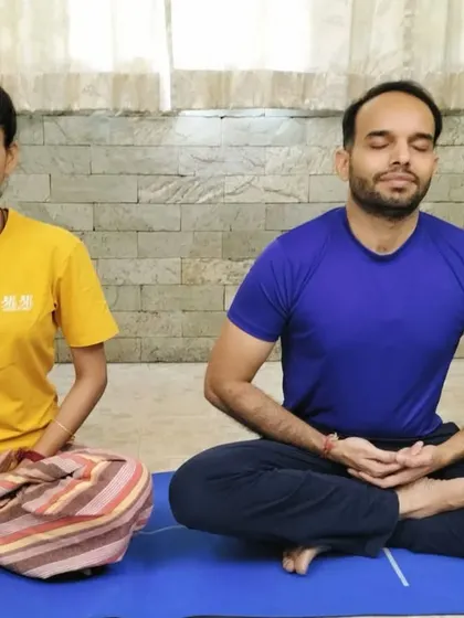 A couple meditates together indoors. This image, shared for World Meditation Day, celebrates the beauty of shared silence and the strength it brings to a relationship.