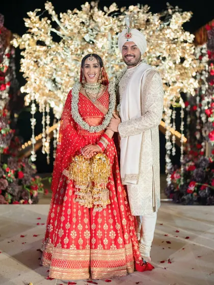 The bride and groom in front of their unique mandap at the Oberoi, Marrakech. The centerpiece is a magnificent golden tree with intricate mauli work, a perfect blend of Indian craftsmanship and destination grandeur.