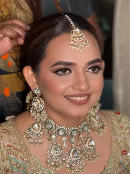 A candid moment of a bride getting ready, her hair styled in a classic floral bun. This updo is a perfect foundation for any bridal look.