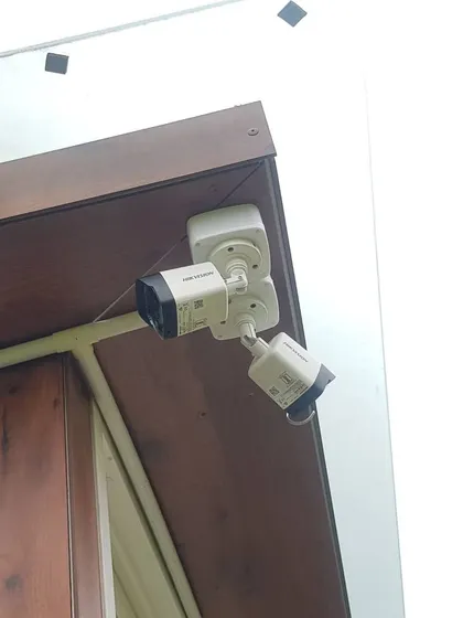 Here are two Hikvision bullet cameras installed neatly under an eave. This placement protects the cameras and provides a clear view of the side of the house.