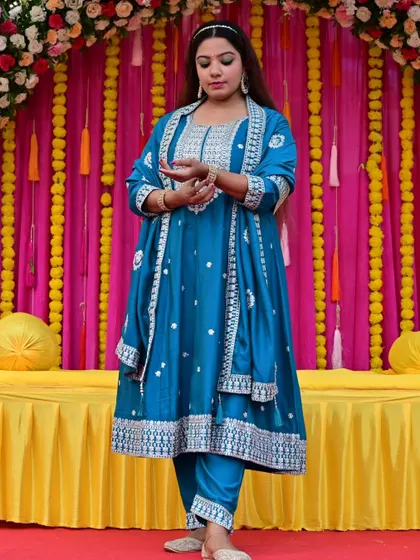 Showcasing a stunning turquoise Anarkali suit. This vibrant color and intricate silver embroidery make it a standout choice for festive daytime events like a Mehendi or Haldi.