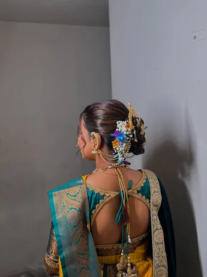 A detailed shot of a traditional Maharashtrian bridal bun, complete with intricate floral arrangements and classic hair accessories.